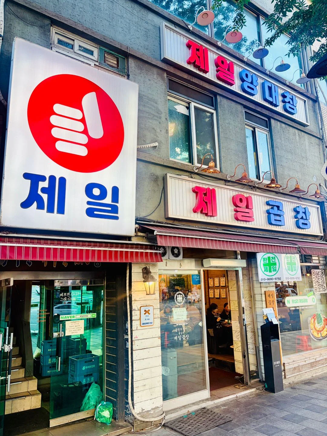 昼の外観 — 1階の「제일곱창」の看板とストライプのひさし