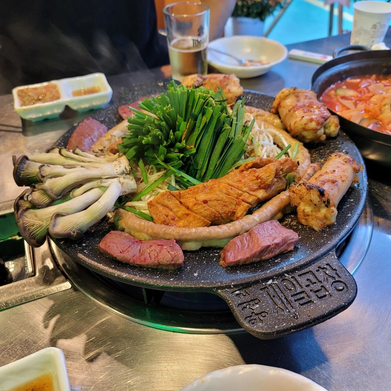「제일곱창 왕십리」と刻まれた鉄板のコプチャン焼きとニラ